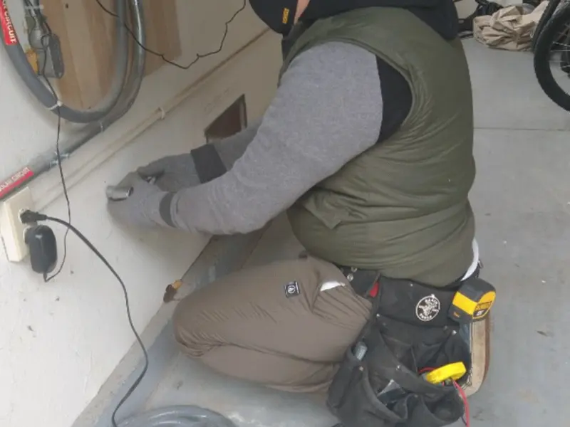 Electrician performing outlet wiring in a Lockland garage